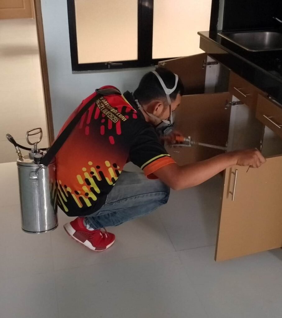 Jansen Pest Control technician applying indoor pest treatment in a Boracay kitchen.
